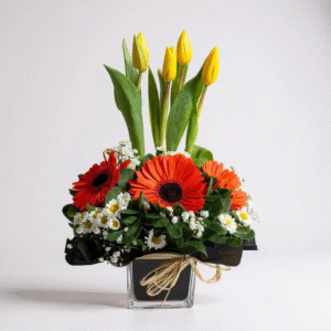 Cubo de vidrio con gerberas y tulipanes